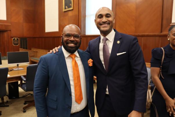 Two men in blue suits pose for a picture together