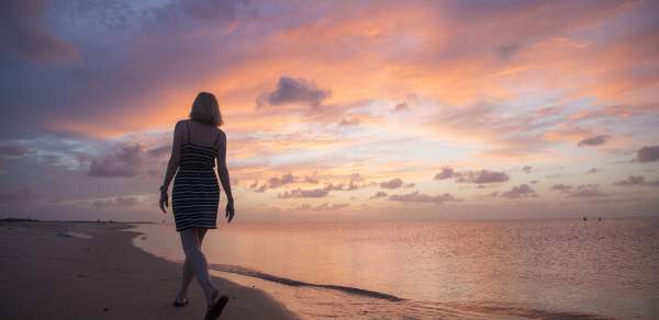 Woman walking along the shore on Dauphin Island's beach
