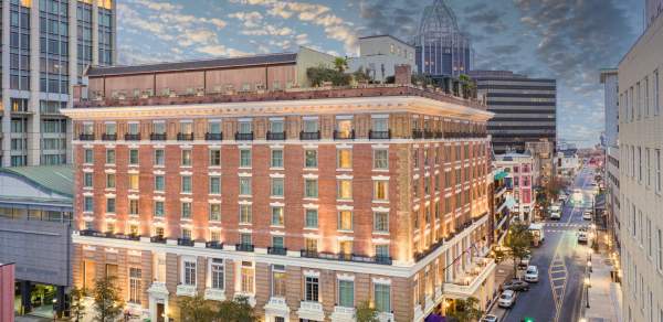 Exterior of Battleship Hotel at night: seven story brick building