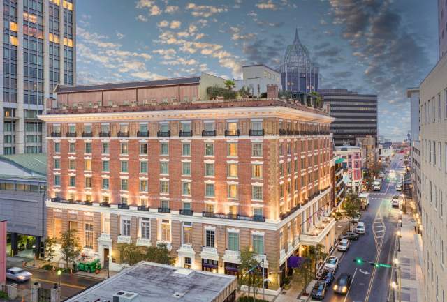 Exterior of Battleship Hotel at night: seven story brick building