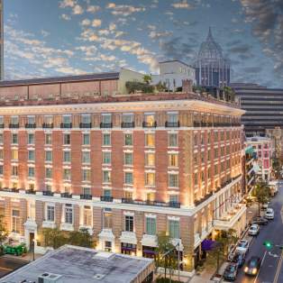Exterior of Battleship Hotel at night: seven story brick building