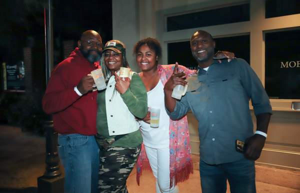 four people hugging and smiling