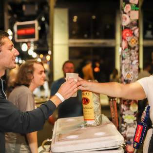 Person receiving a drink at a bar during Dauphin Street Beer Fest