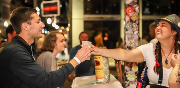 Person receiving a drink at a bar during Dauphin Street Beer Fest