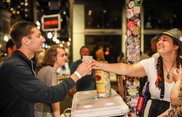 Person receiving a drink at a bar during Dauphin Street Beer Fest