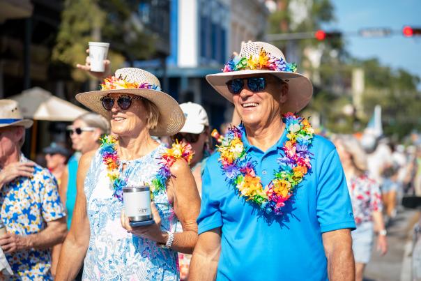 Middle-aged couple wearing bold blue clothes, hats and leis