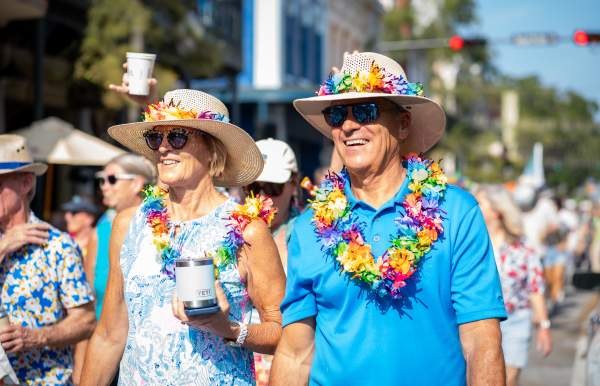 Middle-aged couple wearing bold blue clothes, hats and leis