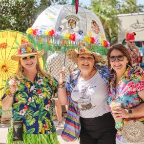 Group of women dressed in tropical clothes with umbrellas