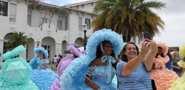 lady posing with an Azalea trail maid in front of the History Museum