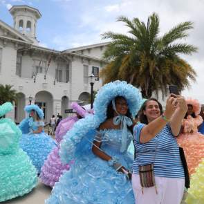 lady posing with an Azalea trail maid in front of the History Museum