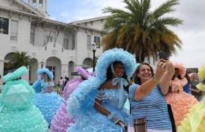 lady posing with an Azalea trail maid in front of the History Museum
