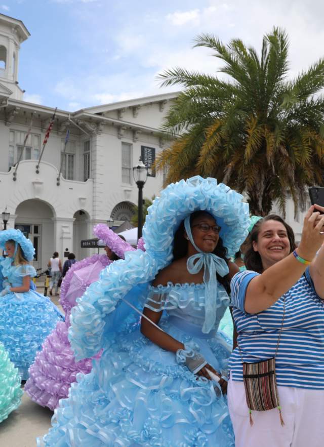 lady posing with an Azalea trail maid in front of the History Museum