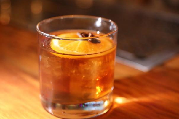 A rocks glass of whisky sits on a bar