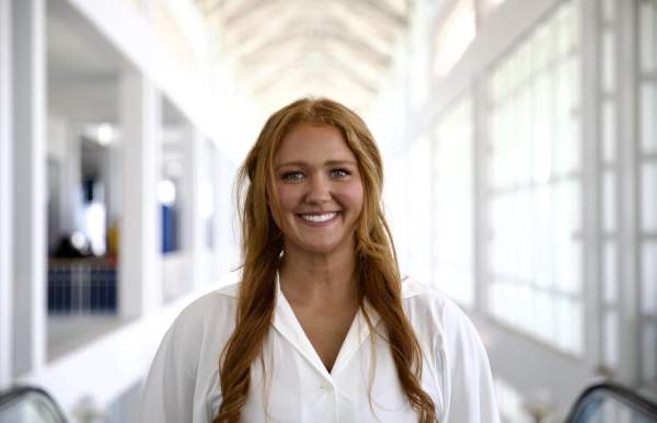 Woman wearing a white button down shirt smiling