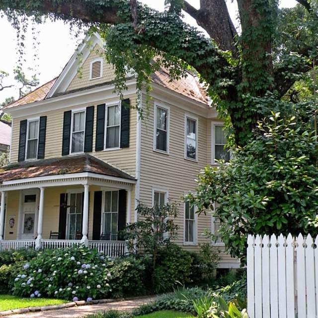 historic two story home with white picket fence