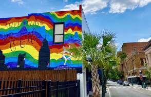 building with a mural of the city and a rainbow background