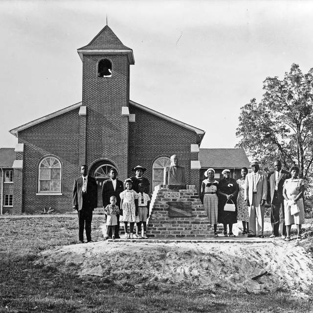 black and white photo of a group of people standing in front of a church