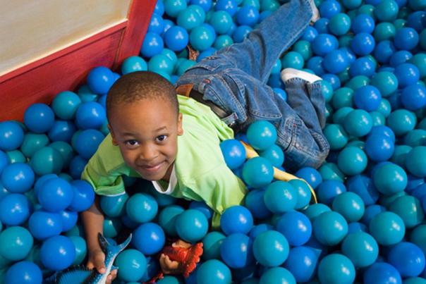 small child playing in a ball pit