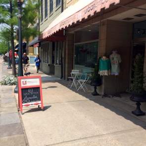 chalkboard sign on the sidewalk in front of a retail store