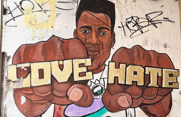 African American man holding up his hands with rings that read Love and Hate