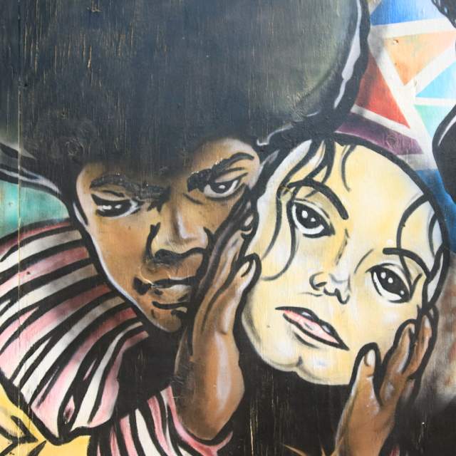 Mural of young Michael Jackson holding a mask of adult Michael Jackson