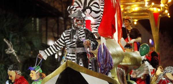 man in striped costume standing on a Mardi Gras float