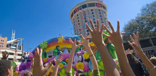 crowd at Mardi Gras holding up their hands