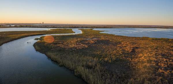 water and grass land masses at sunset