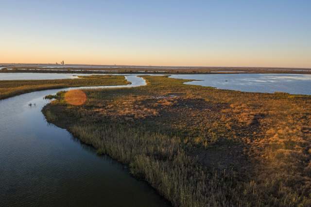 water and grass land masses at sunset