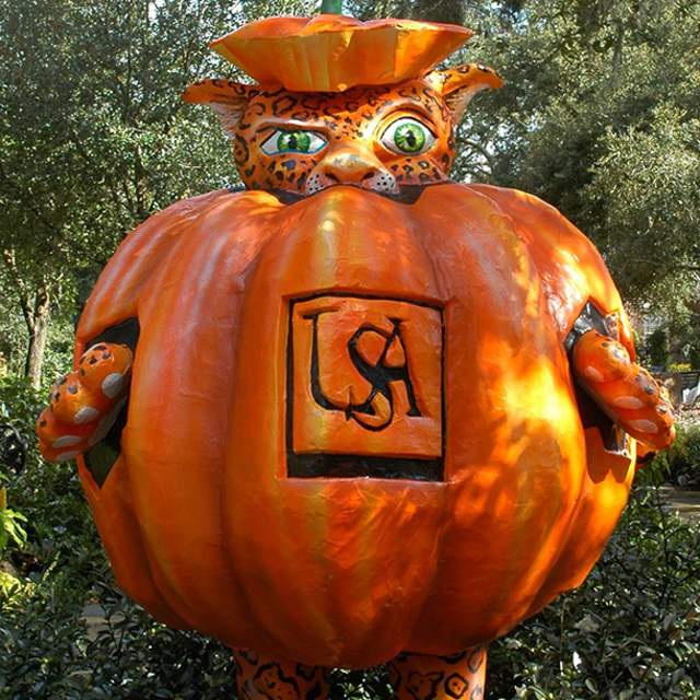 Sculpture of a pumpkin with University of South Alabama logo and a jaguar sticking his head out of the top