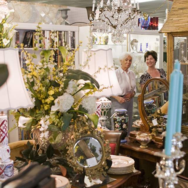 Two women in the background of a room with candles and lamps