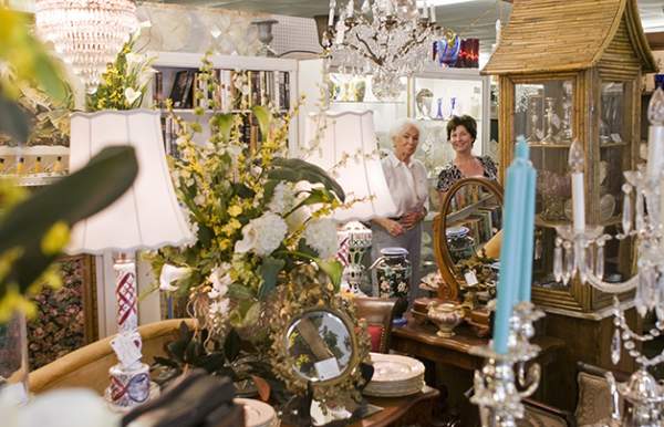 Two women in the background of a room with candles and lamps