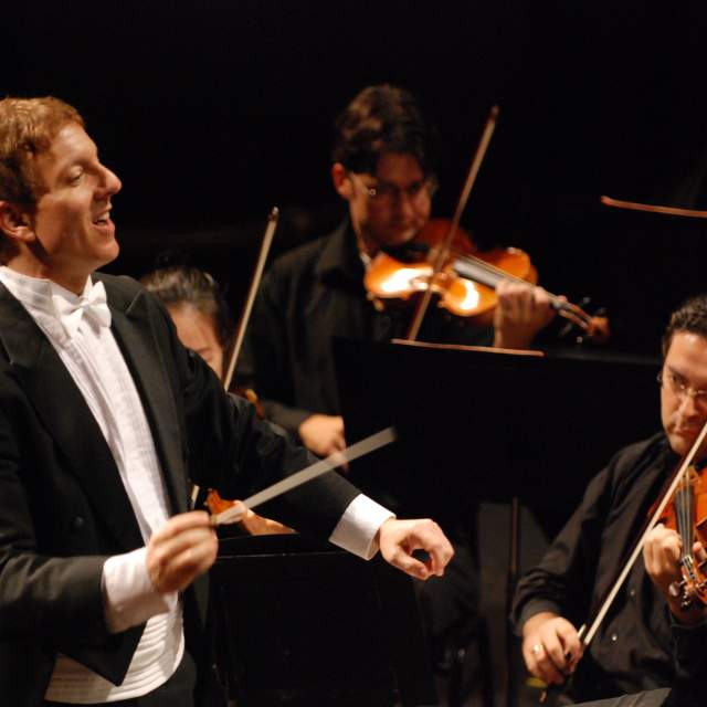 conducter and violin players at a concert