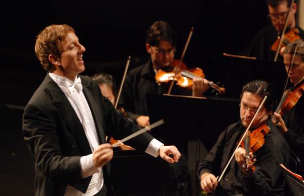 conducter and violin players at a concert