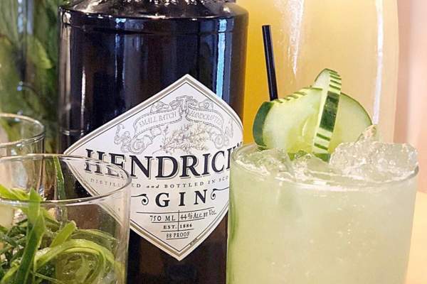 two cocktails and a gin bottle