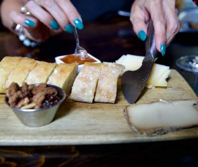 Charcuterie board with bread, nuts, cheese and preserves