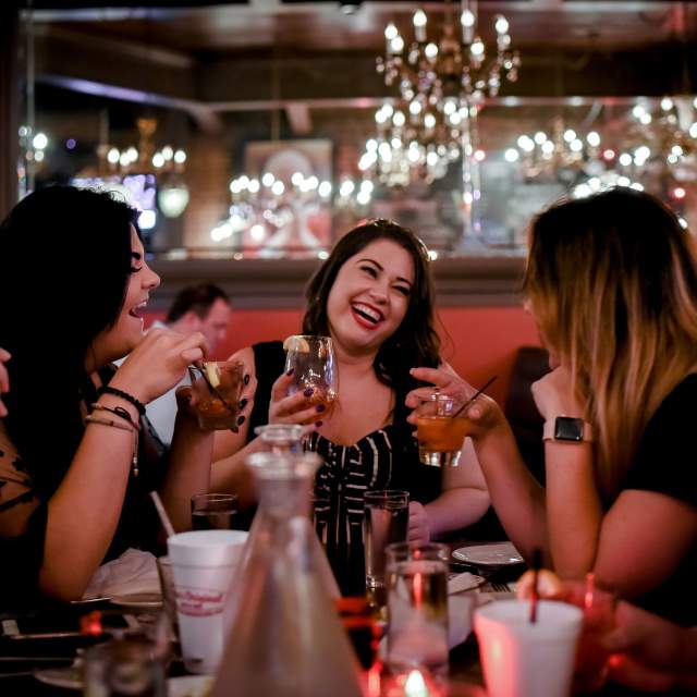 group of women drinking cocktails in a restaurant