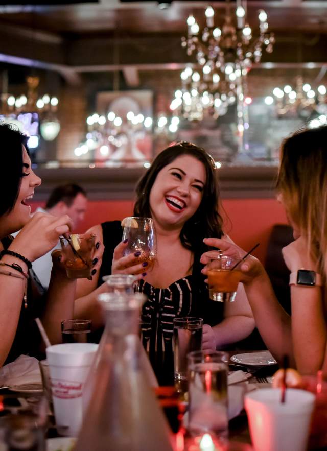 group of women drinking cocktails in a restaurant