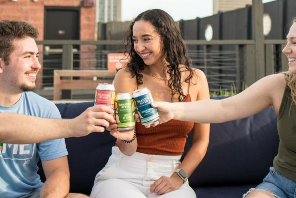 three people toasting with beer