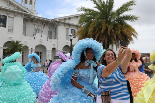 lady posing with an Azalea trail maid in front of the History Museum